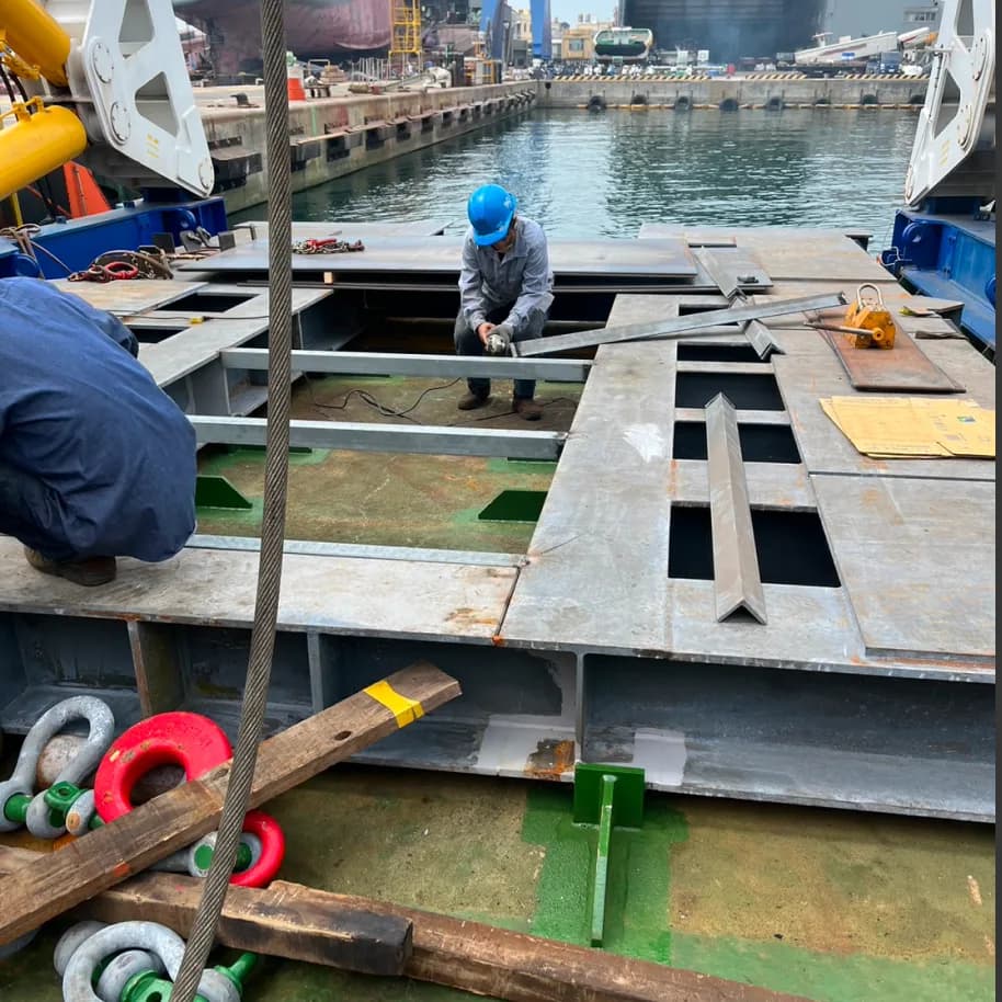 The platform deck at the quayside, its plating already cut with rectangular openings to suit the base positions.
