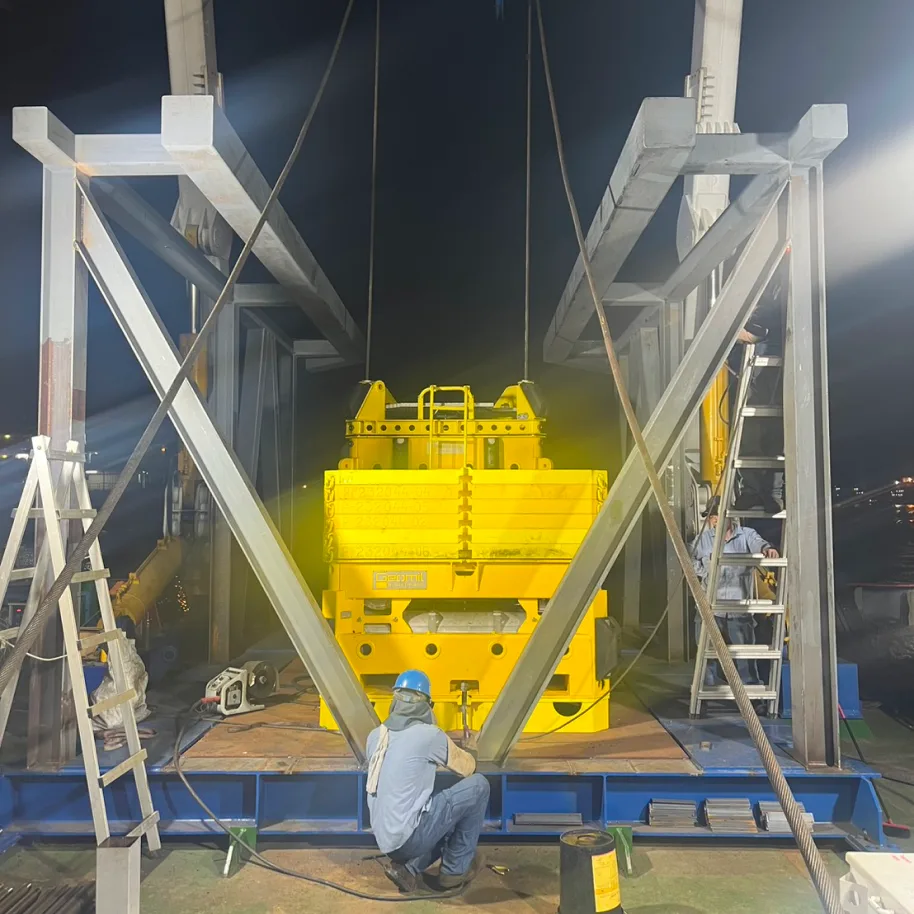 The frames up at night and the equipment lowered into place, with the crew securing it at the base.